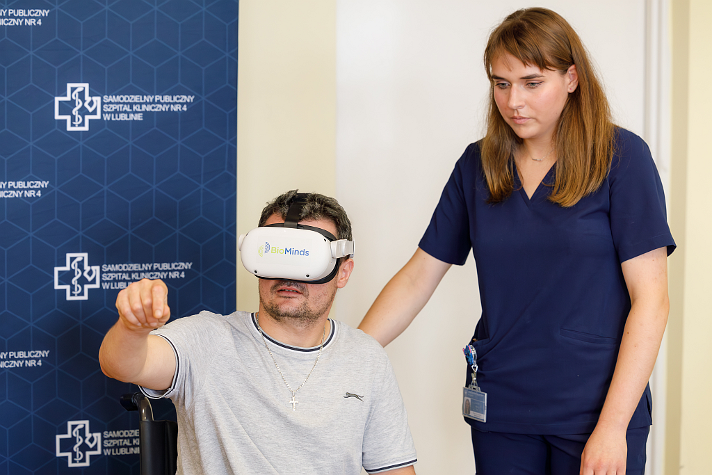 Pacjent w okularach VR ćwiczący z fizjoterapeutką