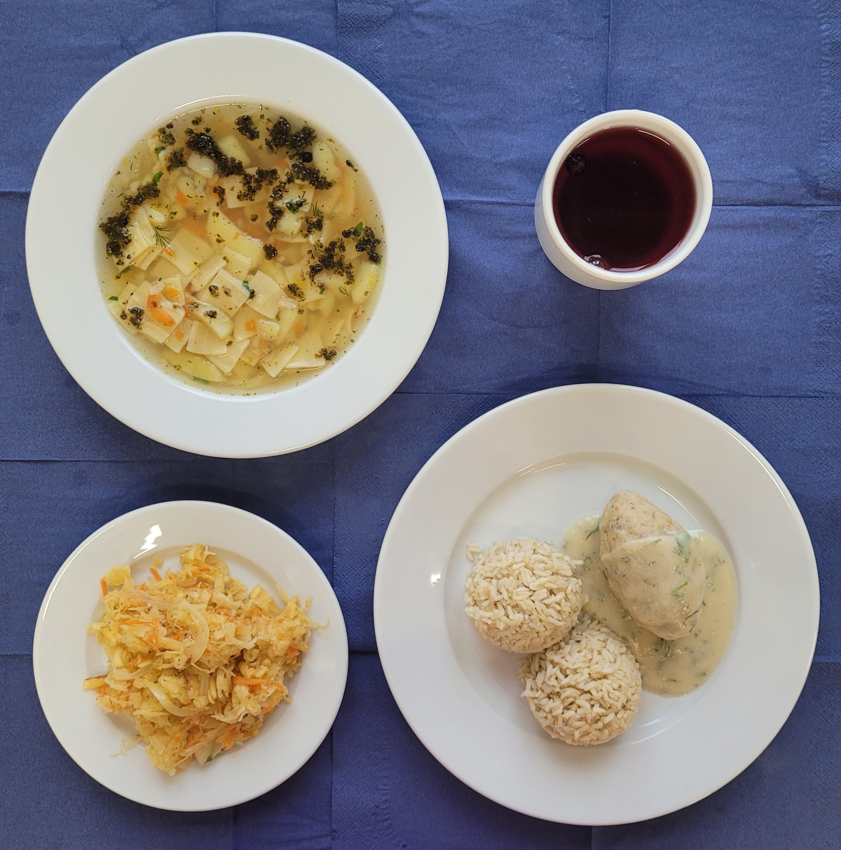 na talerzach zupa zacierka, pulpet rybny, ryż brązowy, sos koperkowy, surówka z kiszonej kapusty, w kubku kompot 