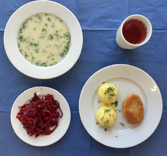 na talerzach zupa selerowa, kotlet pożarski, ziemniaki, surówka z buraczka w kubku kompot 