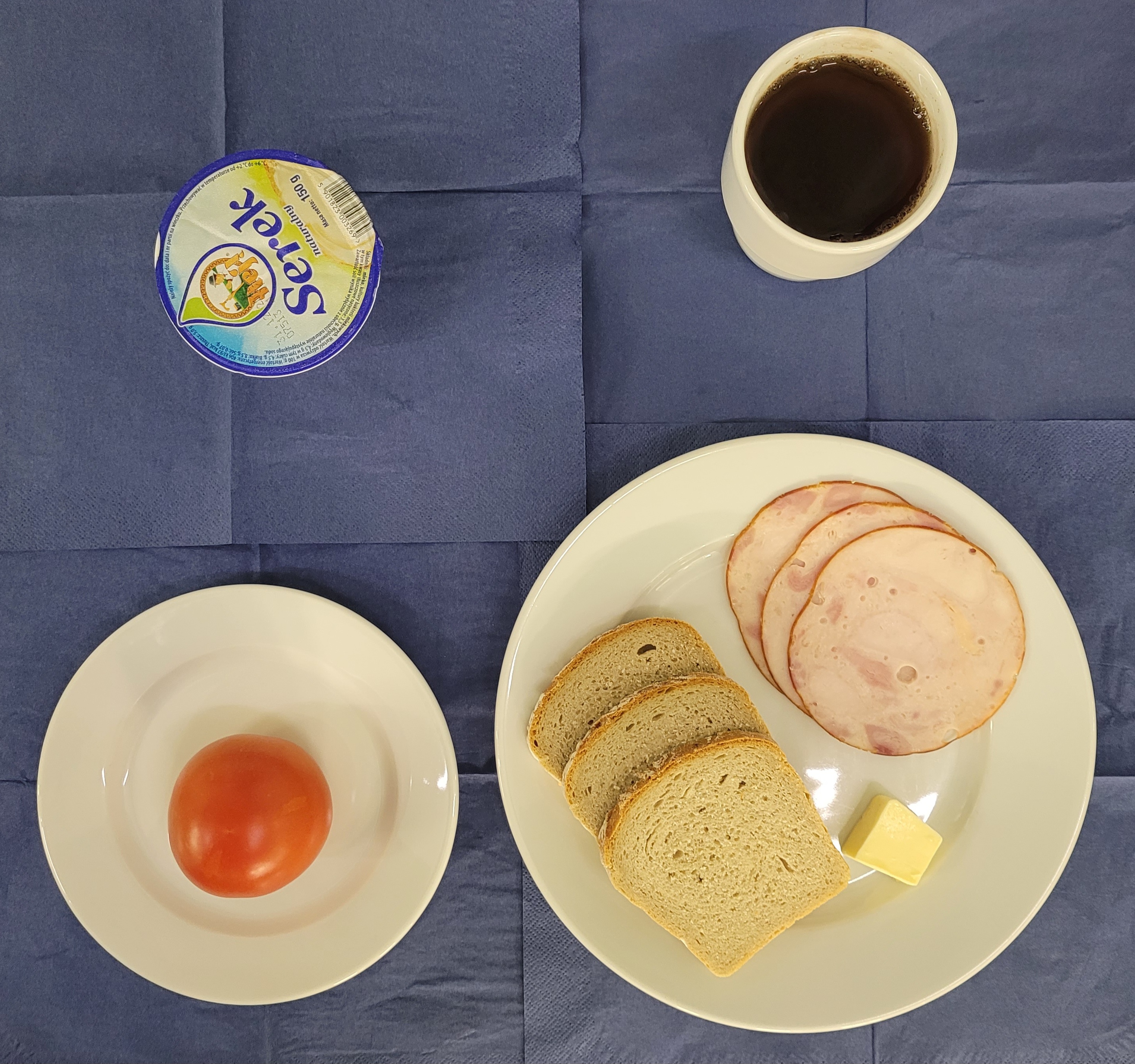 na talerzach chleb razowy, masło, szynka z indyka, pomidor, serek homogenizowany, w kubku herbata z cytryną